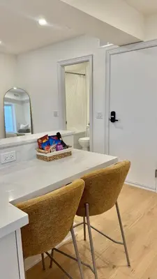 a kitchen with a table with two chairs and a mirror at Bright & Cozy Private Studio Apartment in Toronto