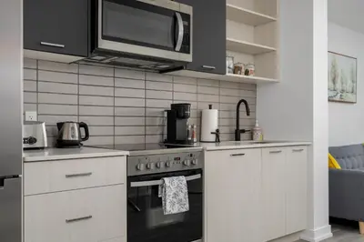 a kitchen with a stove and a microwave at Modern 2 Bed Condo in the Junction+Parking in Toronto