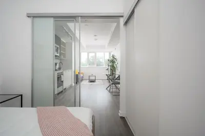 a bedroom with a bed and a living room at Modern 2 Bed Condo in the Junction+Parking in Toronto