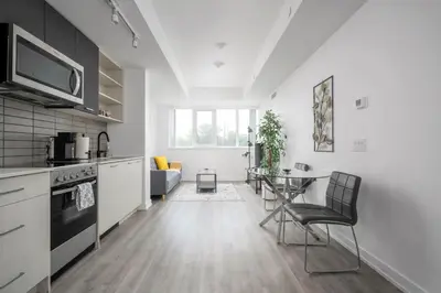 a kitchen and living room with a table at Modern 2 Bed Condo in the Junction+Parking in Toronto