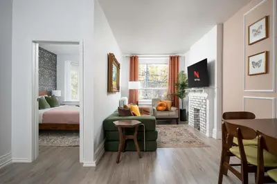 a living room with a green couch and a bedroom at Vintage Charm on Roncesvalles in Toronto
