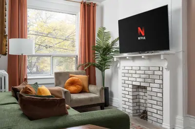 a living room with a tv above a fireplace at Vintage Charm on Roncesvalles in Toronto