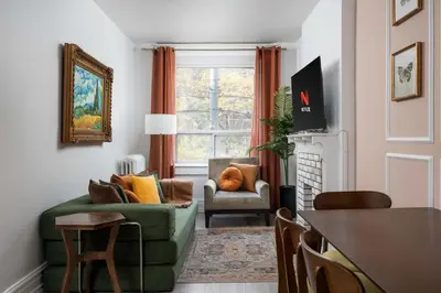 a living room with a green couch and a chair at Vintage Charm on Roncesvalles in Toronto