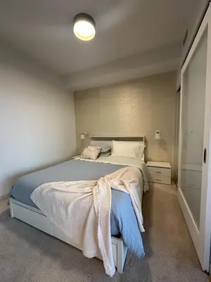 a bedroom with a bed with a blue blanket on it at Brightly Lit Suite Centrally Located |UofT|Ryerson in Toronto