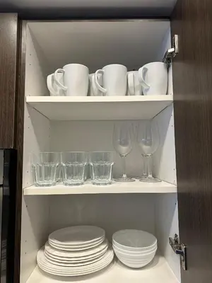 a cabinet with plates and cups and glasses on shelves at Brightly Lit Suite Centrally Located |UofT|Ryerson in Toronto