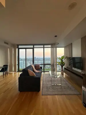 a living room with a couch and a large window at Brightly Lit Suite Centrally Located |UofT|Ryerson in Toronto