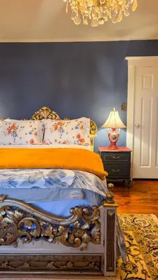 a bedroom with a bed and a lamp on a table at The Farmhouse Manor B&B in St. Catharines