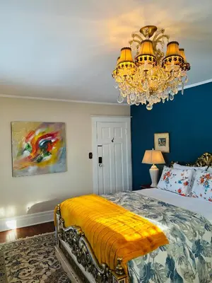 a bedroom with a bed and a chandelier at The Farmhouse Manor B&B in St. Catharines