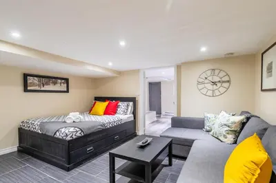 a living room with a bed and a couch at Cozy Suite Condo - Heart Of St Clair West - Bloor Hotel in Toronto