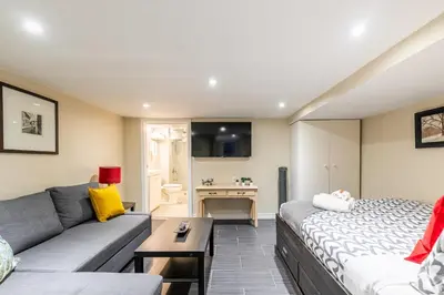 a living room with a couch and a table at Cozy Suite Condo - Heart Of St Clair West - Bloor Hotel in Toronto