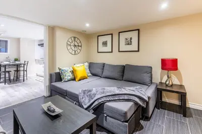 a living room with a couch and a table at Cozy Suite Condo - Heart Of St Clair West - Bloor Hotel in Toronto