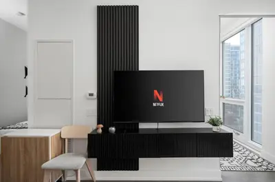 a living room with a tv on a black entertainment center at Style & Comfort in the Heart of Toronto in Toronto