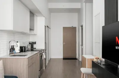 a kitchen with a sink and a television in a room at Style & Comfort in the Heart of Toronto in Toronto