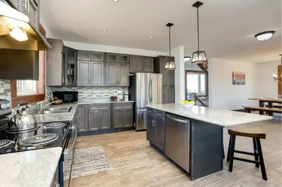 a large kitchen with stainless steel appliances and wooden cabinets at Grand 8-Bedroom Retreat 7 Baths Hot Tubs - Perfect Chalet in Blue Mountains