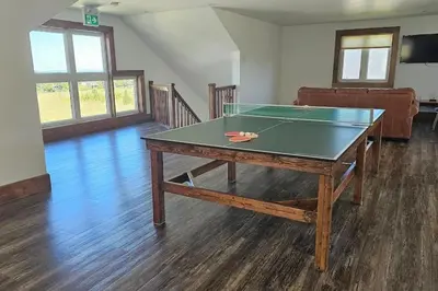 a ping pong table in a living room with a table at Grand 8-Bedroom Retreat 7 Baths Hot Tubs - Perfect Chalet in Blue Mountains
