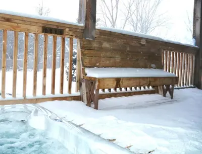 a bench sitting on a porch covered in snow at Grand 8-Bedroom Retreat 7 Baths Hot Tubs - Perfect Chalet in Blue Mountains