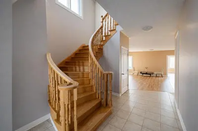 a wooden staircase in a home with a hallway at Private & Spacious King-size Bedroom with 3 Bath access! Brampton Shared Home with Full Kitchen, WiFi, Laundry & Backyard Deck! Near Mount Pleasant GO, Ideal for Work Trips, Long Stays & Solo Travelers! in Brampton