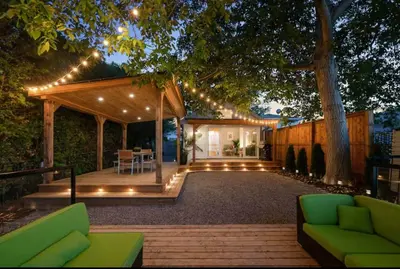 a backyard with a pergola and a patio with green furniture at Luma Lakehouse Icewine Lakefront | Deck + Hot Tub in St. Catharines