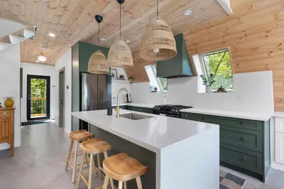 a kitchen with white countertops and green cabinets at Sauna Hot Tub Lake Off-Grid AFrame Retreat in Gravenhurst