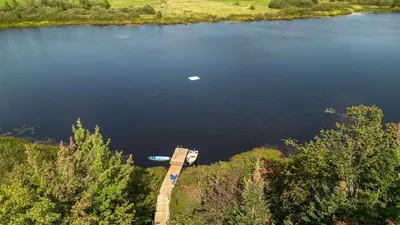 an aerial view of a lake with a dock at Sauna Hot Tub Lake Off-Grid AFrame Retreat in Gravenhurst