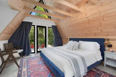 a bedroom with a bed and a wooden ceiling at Sauna Hot Tub Lake Off-Grid AFrame Retreat in Gravenhurst