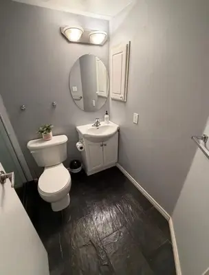 a bathroom with a toilet and a sink and a mirror at apartment for 4 guests in Port Hope