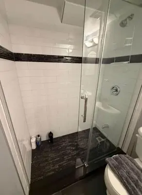 a bathroom with a glass shower with a toilet at apartment for 4 guests in Port Hope