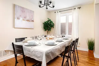 a dining room with a white table and chairs at House with 5 Beds for Families in Great Location in Mississauga