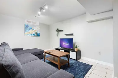 a living room with a couch and a tv at Roomy 1BD Apartment in Basement of House in Mississauga