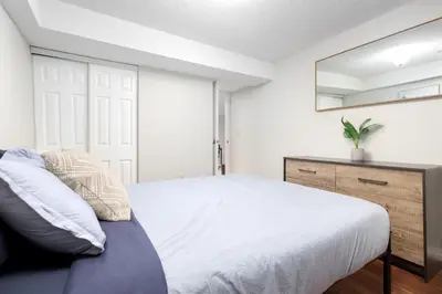 a bedroom with a bed and a mirror at Roomy 1BD Apartment in Basement of House in Mississauga