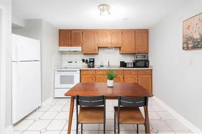 a kitchen with a wooden table and chairs at Roomy 1BD Apartment in Basement of House in Mississauga