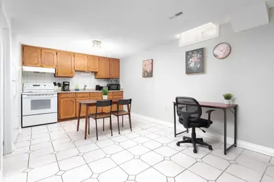 a kitchen with wooden cabinets and a table and chairs at Roomy 1BD Apartment in Basement of House in Mississauga
