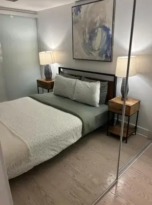 a bedroom with a bed with two tables and two lamps at Apartment for 4 trundle Bay in Port Hope