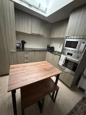 a kitchen with a wooden table and a microwave at Nice view apartment office den in Port Hope