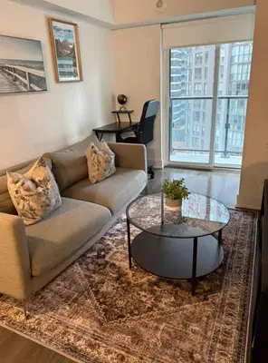 a living room with a couch and a table at Queen Bed and single bed for friends in Port Hope