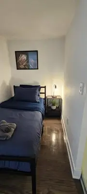 a bedroom with a bed with blue sheets and a staircase at Queen Bed and single bed for friends in Port Hope
