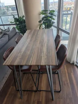a wooden table and chairs in a room with a window at Nice Place Central to Downtown in St. Catharines