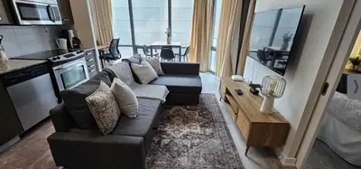 a living room with a couch and a table in a kitchen at Functional Condo Sleep 6 in Port Hope