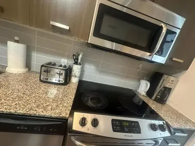 a kitchen with a stove and a microwave at Functional Condo Sleep 6 in Port Hope