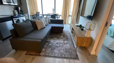 a living room with a couch and a table at Functional Condo Sleep 6 in Port Hope