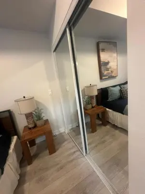 a living room with a mirror and a couch at Functional Condo Sleep 6 in Port Hope