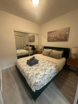 a bedroom with a large bed and a large mirror at Functional Condo Sleep 6 in Port Hope