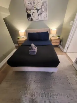 a bedroom with a large bed with two night stands at Small Apartment for 2 in St. Catharines