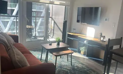 a living room with a couch and a table and a tv at Sleep 2 guests cozy couch in Port Hope