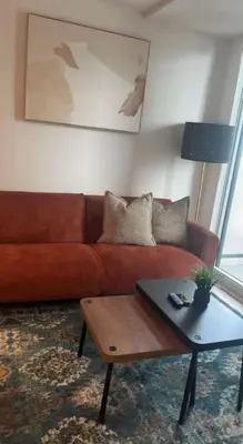 a living room with a brown couch and a coffee table at Sleep 2 guests cozy couch in Port Hope