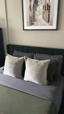 a green bed with two pillows on top of it at Modern Group Condo in Port Hope