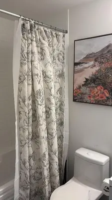 a bathroom with a shower curtain next to a toilet at Modern Group Condo in Port Hope