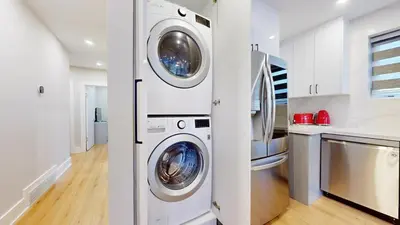 a white laundry room with two washer and dryer at 5 Bedroom Luxury Spa Escape with Pool & Jacuzzi in Toronto