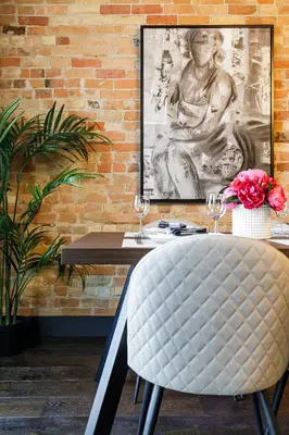 a dining room with a chair and a brick wall at The Brick & Beam Boutique Hotel in Collingwood