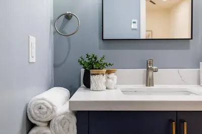 a bathroom with a sink and a mirror and towels at The Brick & Beam Boutique Hotel in Collingwood